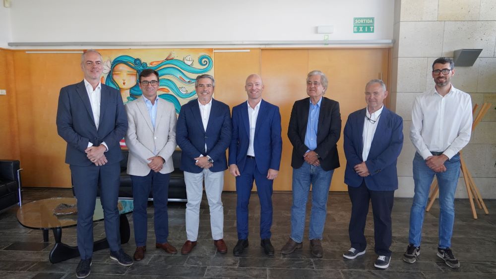 Grupo de personas posando en una reunión con fondo artístico