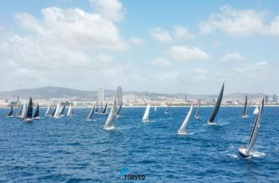 Regata de veleros en Barcelona con el puerto de fondo